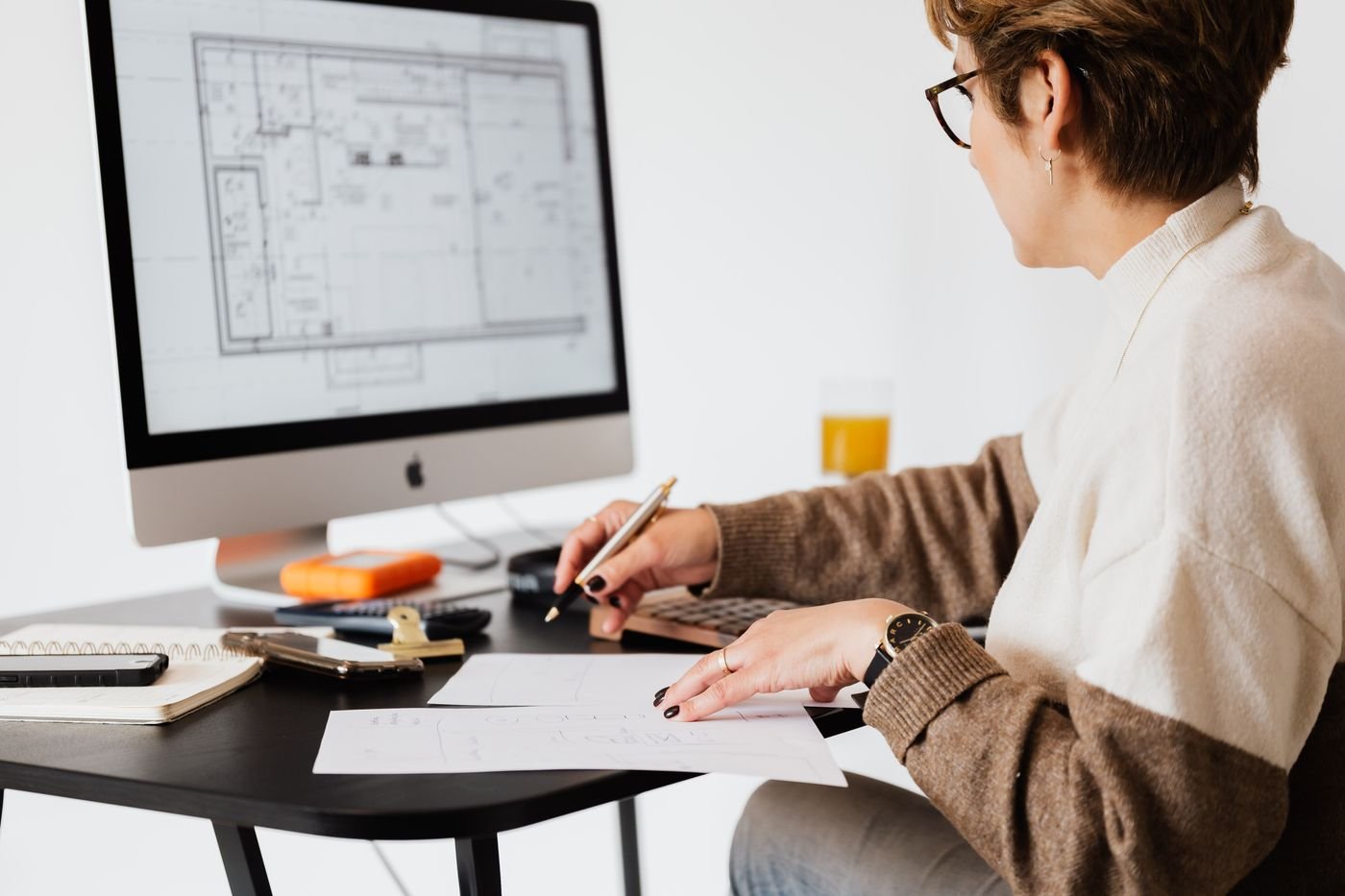 Architect preparing residential floor plans at a studio desk for a builder floor project in Gurugram
