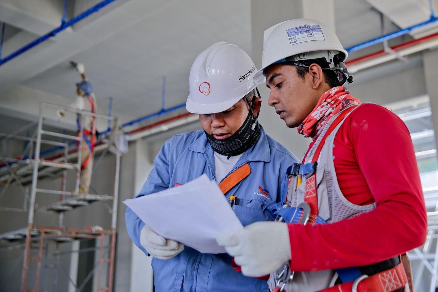 Site engineers reviewing structural drawings during a residential construction project in Delhi NCR