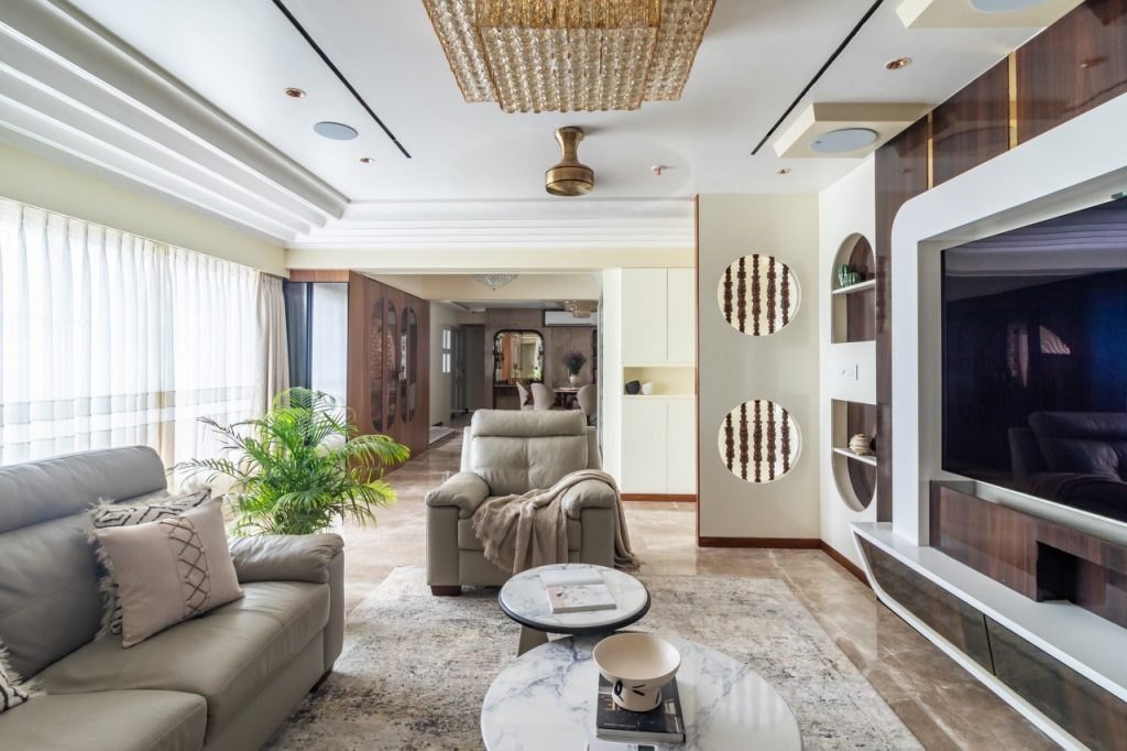 Luxury renovated living room interior in an Indian home with marble floor, layered lighting and custom wall panelling