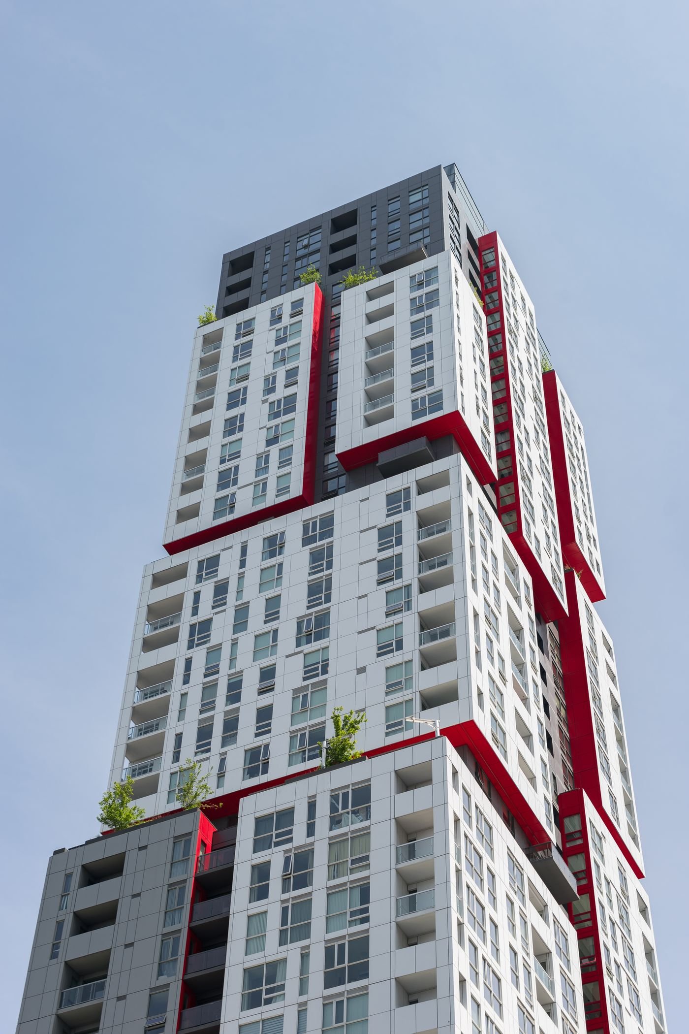 Modern residential tower architecture with clean white facade and red accent lines, typical of new developments near Golf Course Extension Road Gurgaon