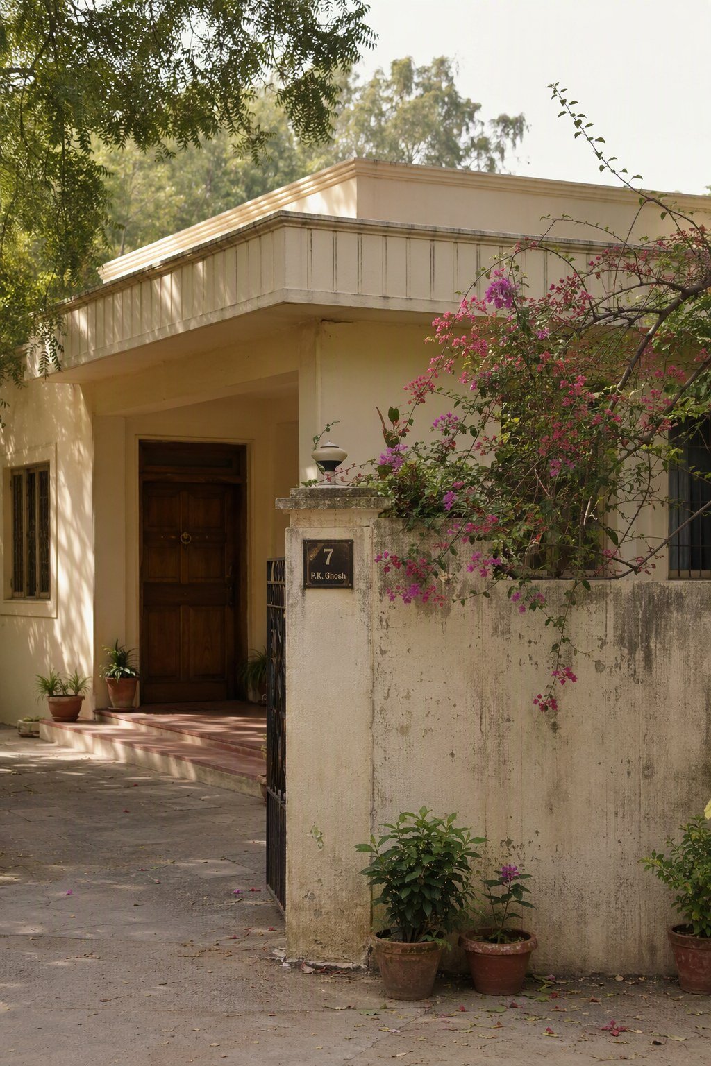 Weathered cream bungalow entrance of an older 1980s Gurugram home, the kind of original character often found in DLF Phase 1