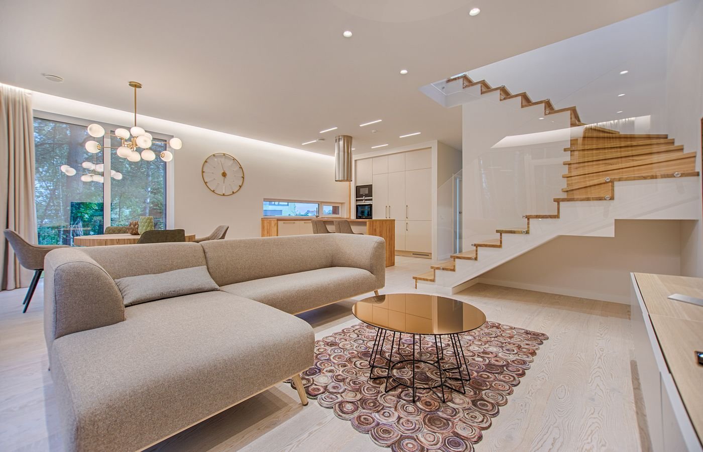 Premium living room interior in a Delhi NCR home with designer furniture, feature staircase and warm layered lighting